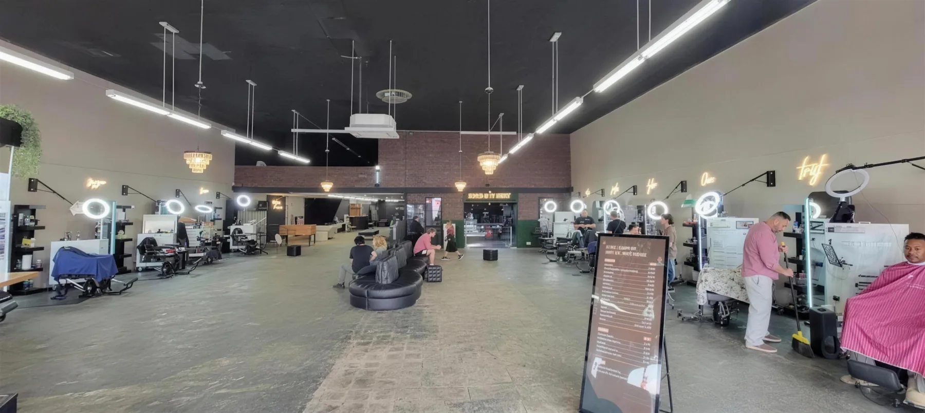 Inside House of Fadez — the main barbershop floor with barbers at work